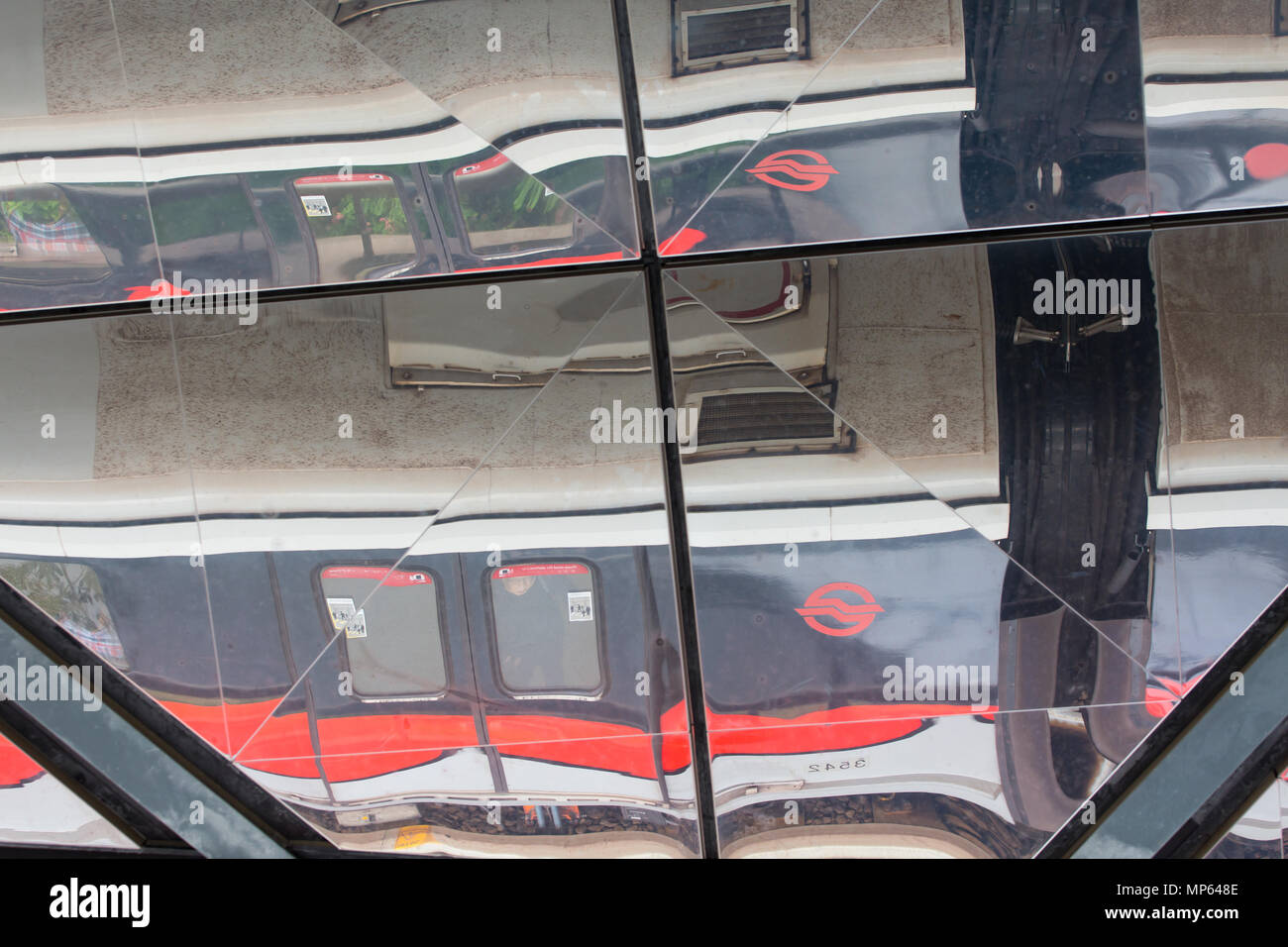 Vista dall'alto riflesso di un treno SMRT che passa accanto a una stazione ferroviaria. Singapore. Foto Stock