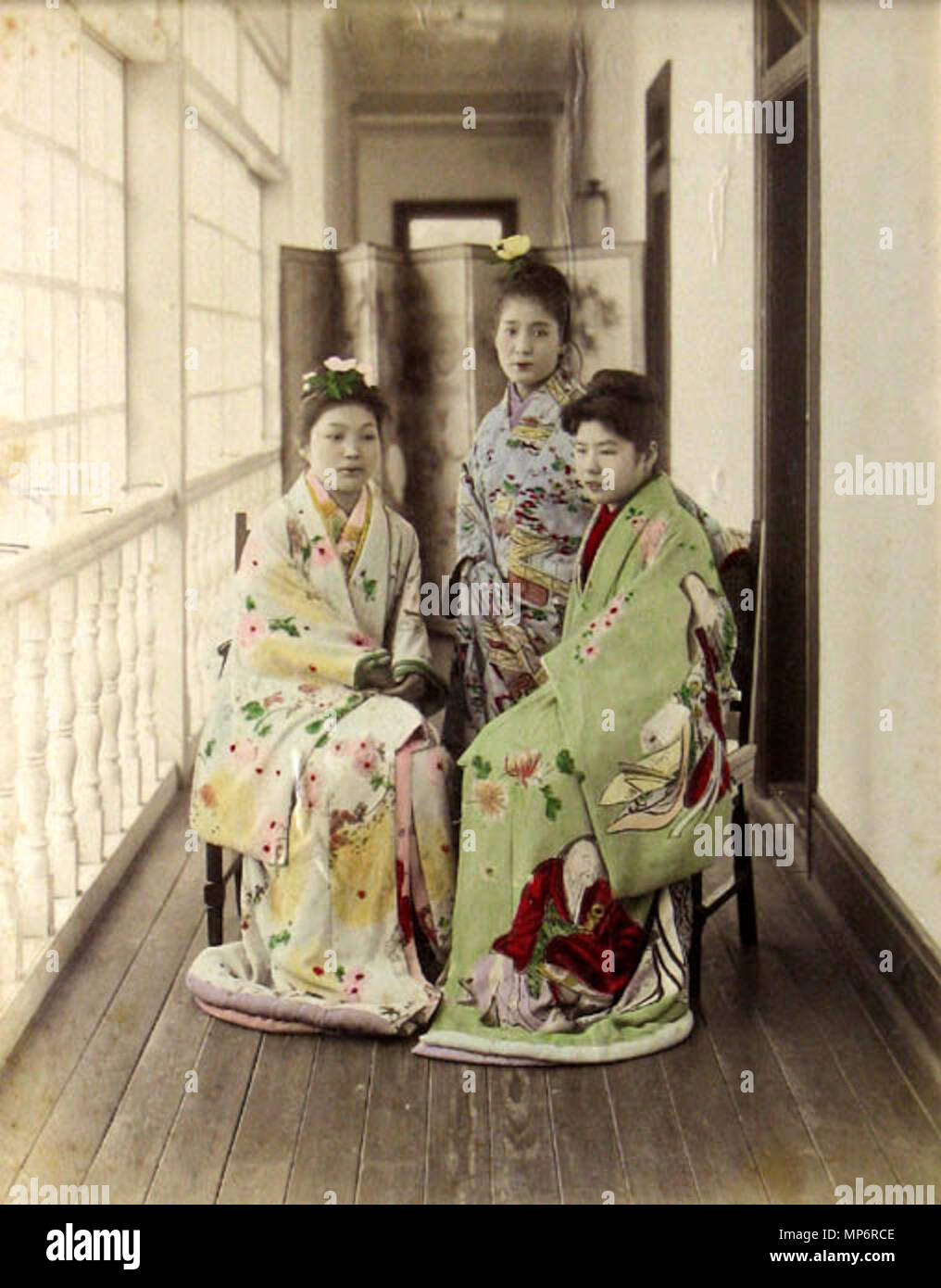 . Tre Yuujo (cortigiane) in posa su un engawa [veranda]. Colorate a mano albume silver stampa da Adolfo Farsari, c.1885. Questi non sono maiko. Maiko non sarebbe obi-meno. Questa immagine è stata scattata in un ben noto bordello a Yokohama, le pesche noci n. 9. Ho visto questa foto come una cartolina offerto su Ebay più volte. Essi sono presumibilmente 'Rasyamen", prostitute per stranieri. 日本語: 1885年横浜、永真遊郭 (真金町)、神風楼 (pesche noci No.9) の 羅紗緬 (外国人専用遊女) . .1885. (19 maggio 2006 (secondo i dati EXIF)). Adolfo Farsari (1841-1898) Descrizione fotografo italiano Data di nascita e morte 11 Febbraio 1841 7 febbraio Foto Stock