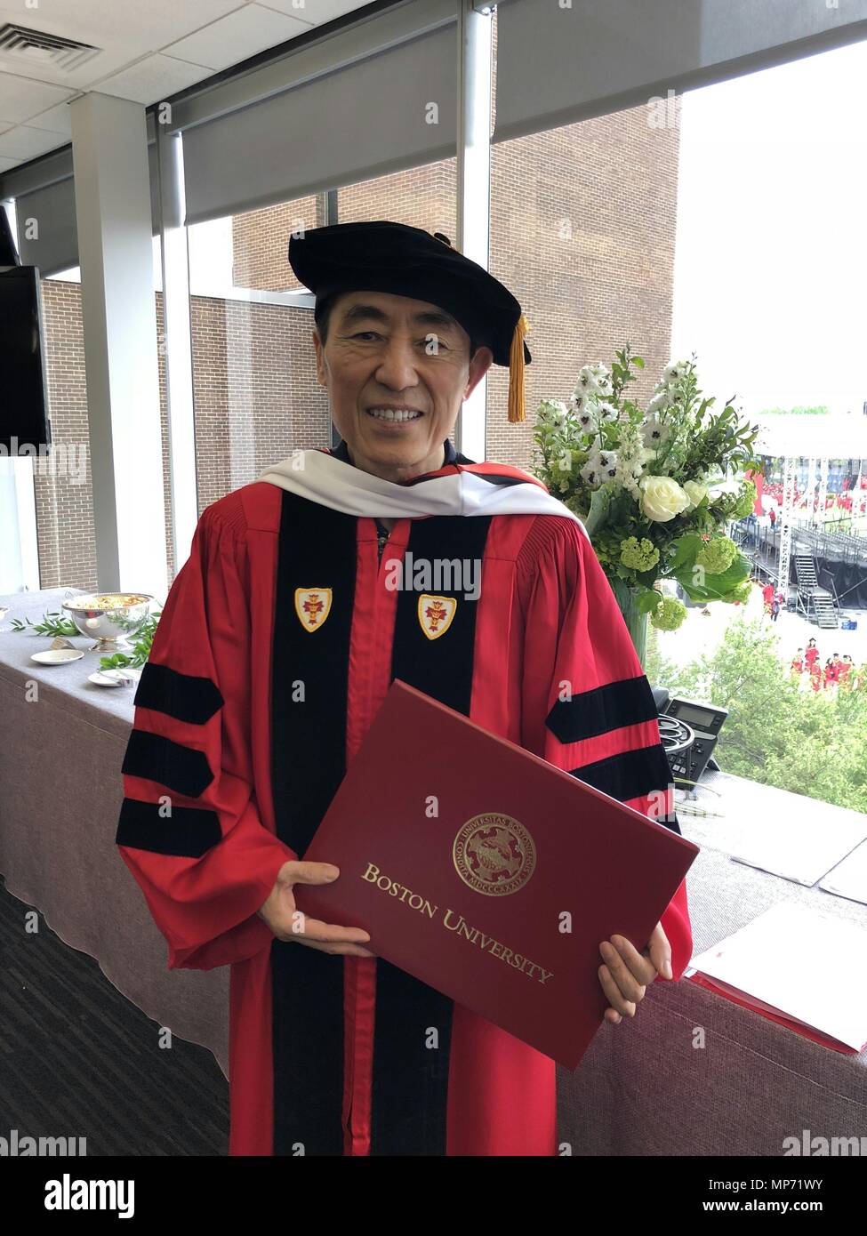 Boston, Stati Uniti d'America. Il 20 maggio 2018. Regista cinese Zhang Yimou visualizza la sua laurea honoris causa certificato come frequenta il 2018 inizio della Boston University di Boston, Stati Uniti, il 20 maggio 2018. Il famoso regista cinese Zhang Yimou di Domenica è stato accolto con acclamazioni e applausi di una folla entusiasta dopo che egli ha ricevuto un dottore honoris causa di umanizzare le lettere della Boston University a sua 145Inizio. Credito: Dong Ding/Xinhua/Alamy Live News Foto Stock