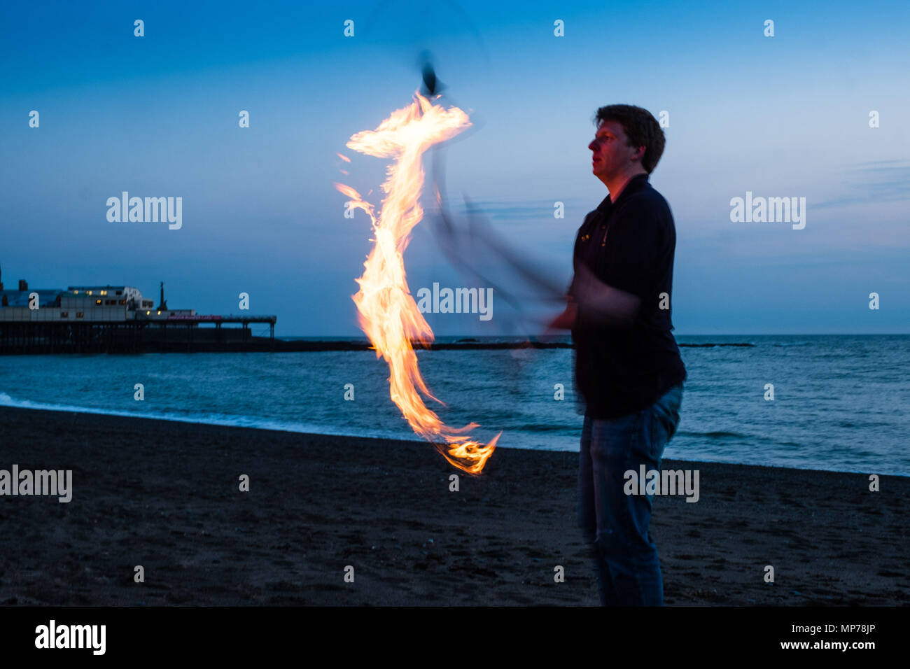 Aberystwyth Wales UK, lunedì 21 maggio 2018 UK Meteo: un uomo giocoleria e giocare con il fuoco sulla spiaggia al tramonto alla fine di una bella giornata di primavera a Aberystwyth , West Wales foto © Keith Morris / Alamy Live News Foto Stock