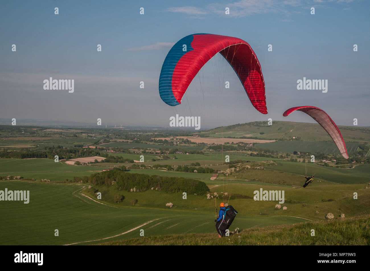 Alciston, East Sussex, Regno Unito. 21 Maggio 2018. I piloti di parapendio al Bo-Peep Hill, nella splendida South Downs che domina la campagna del Sussex, approfittano della brezza dal Nord Est. Foto Stock