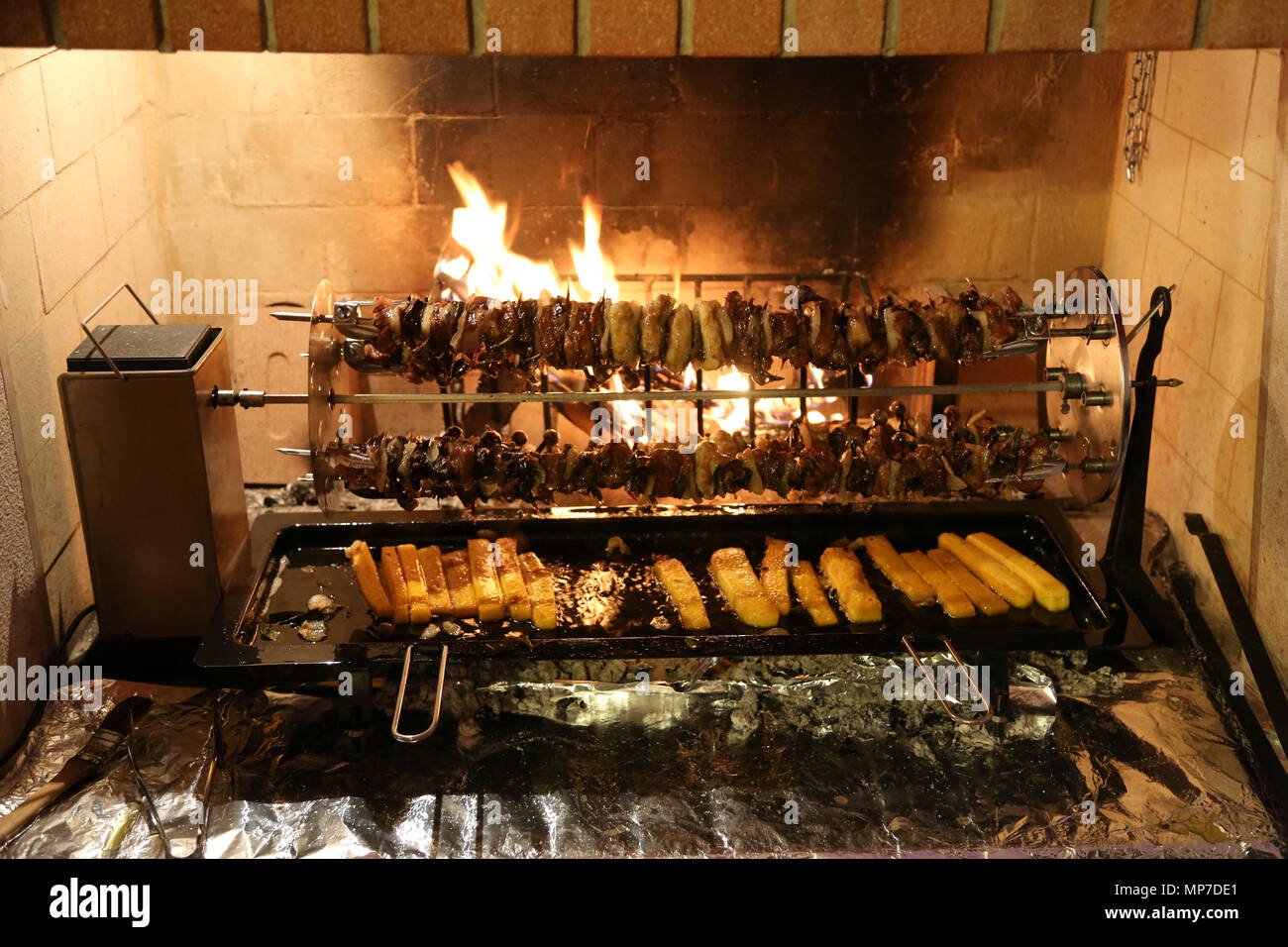 Gli uccelli e la polenta cotta su uno sputo di un camino in un festival Foto Stock