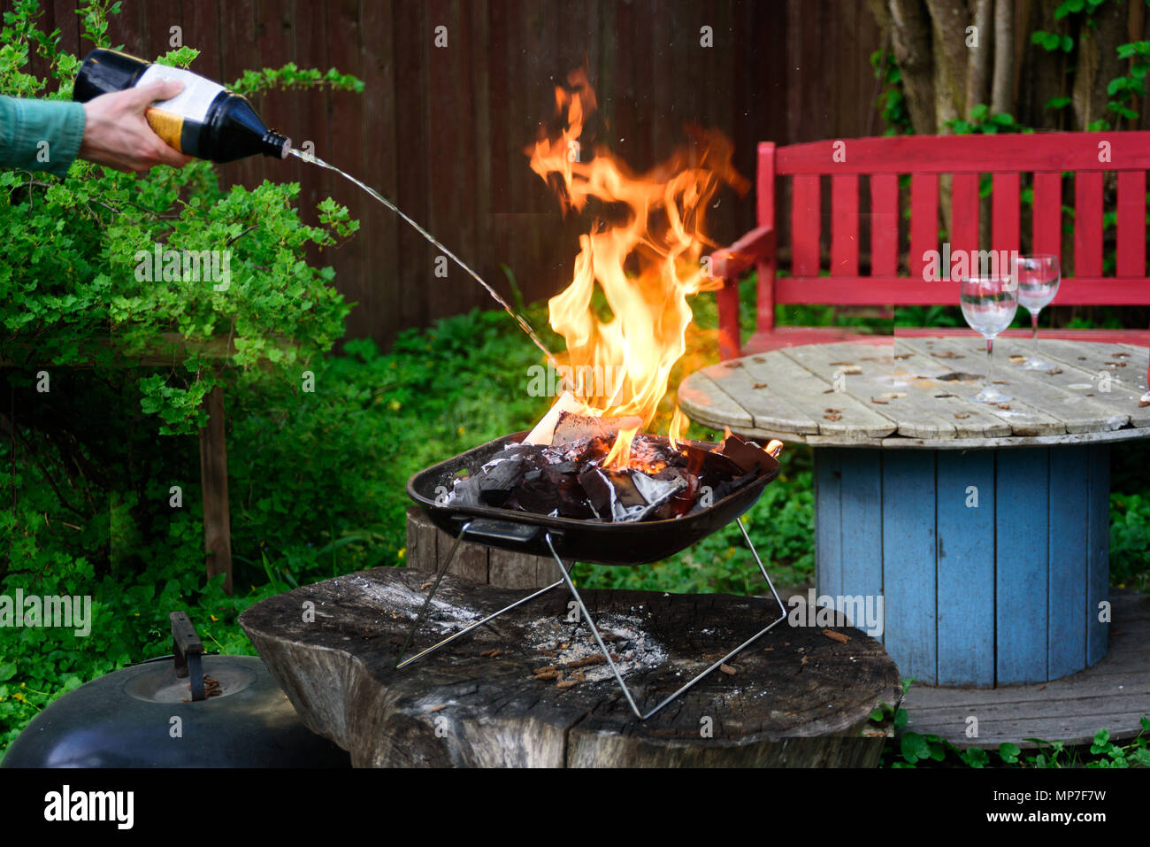 Man mano messa a fuoco griglia per il barbecue su grillware portatile con la cottura il fluido di rifornimento Foto Stock