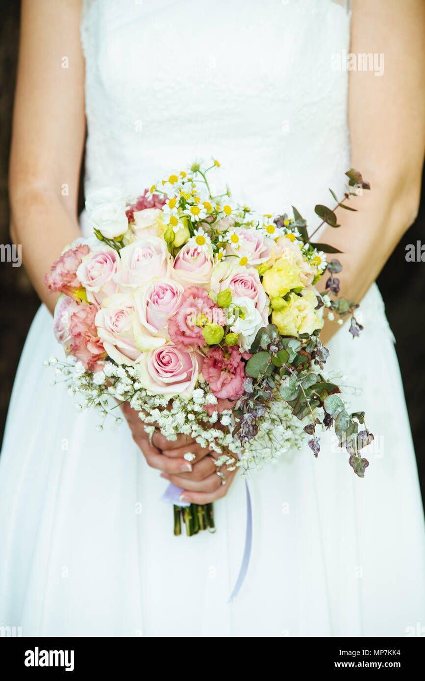 Sposa mantiene il suo bouquet di fiori con rose di edera margherite e  ortensie nel suo giorno di nozze Foto stock - Alamy