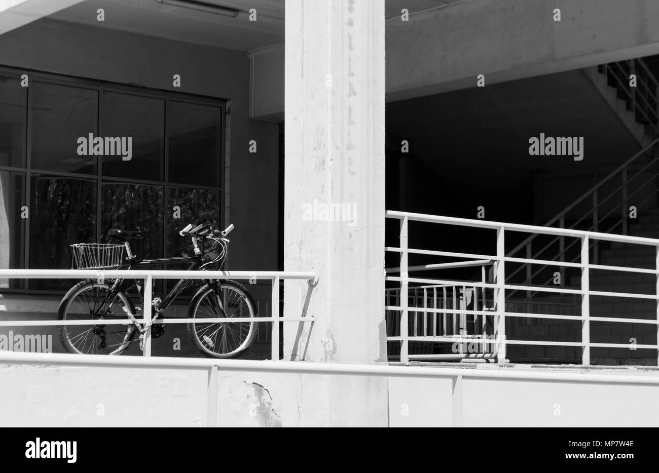 Bicicletta vicino ad un edificio dall'architettura moderna e una scalinata. Foto Stock