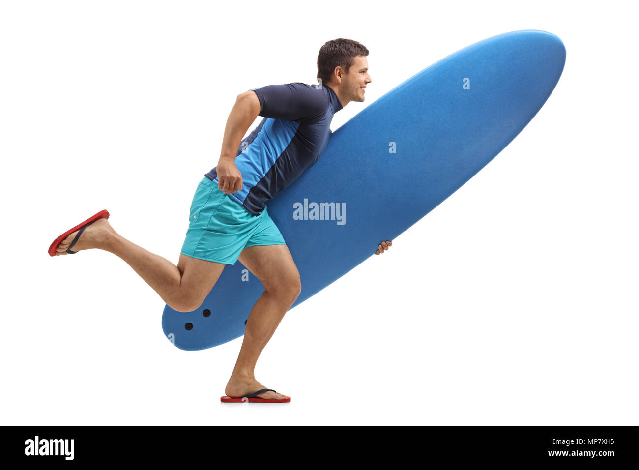 Lunghezza piena ripresa di profilo di un surfista in possesso di una tavola da surf e in esecuzione isolati su sfondo bianco Foto Stock