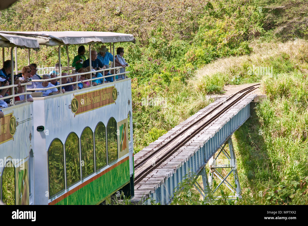 23 febbraio 2015: Basseterre, Saint Kitts- il treno turistico Saint Kitts Scenic Railway porta i passeggeri attraverso un cavalcavia Foto Stock