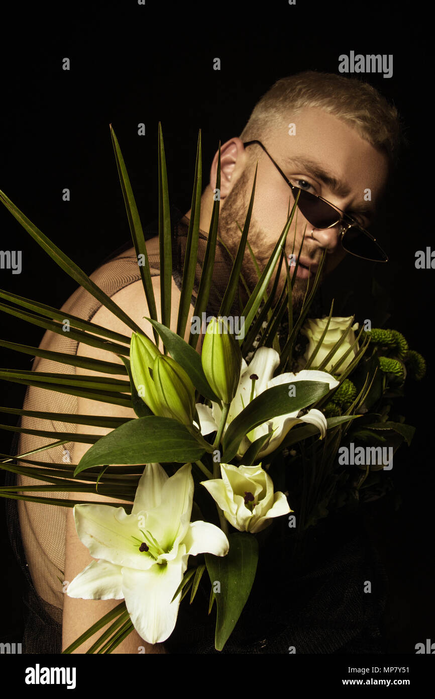 Elegante uomo bianco con bouquet di fiori su sfondo nero Foto Stock