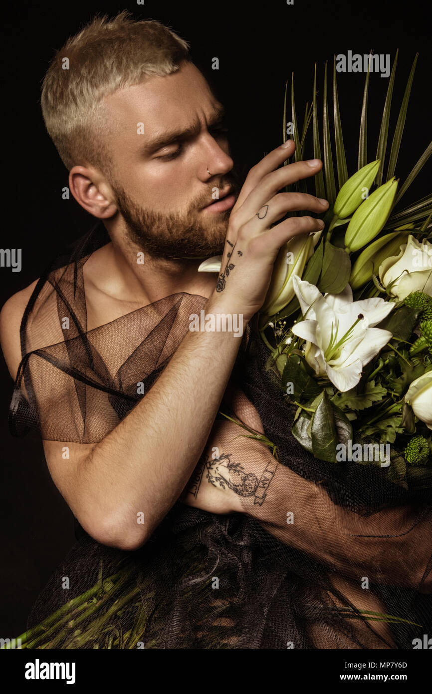 Elegante uomo bianco con bouquet di fiori su sfondo nero Foto Stock