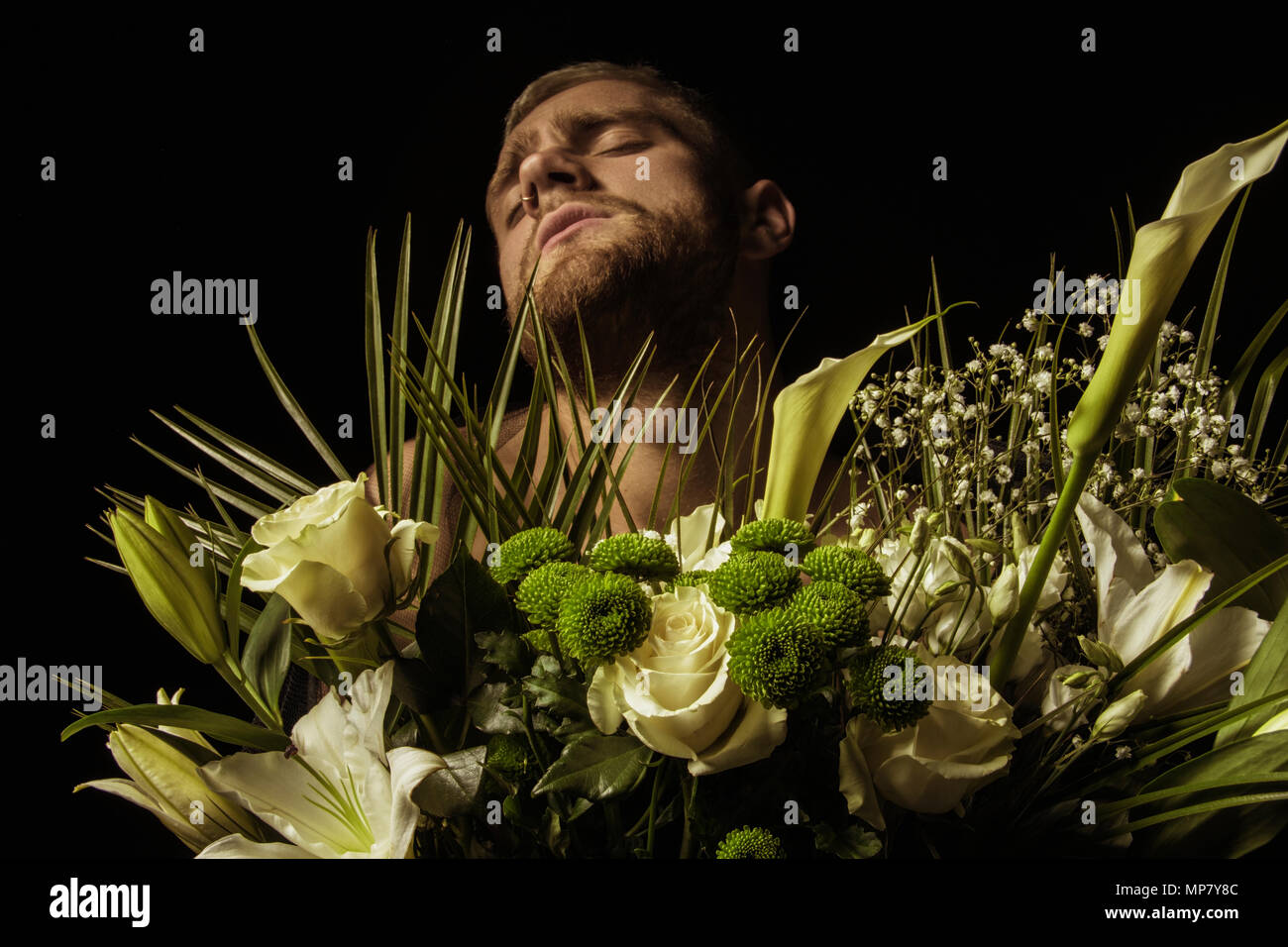 Elegante uomo bianco con bouquet di fiori su sfondo nero Foto Stock