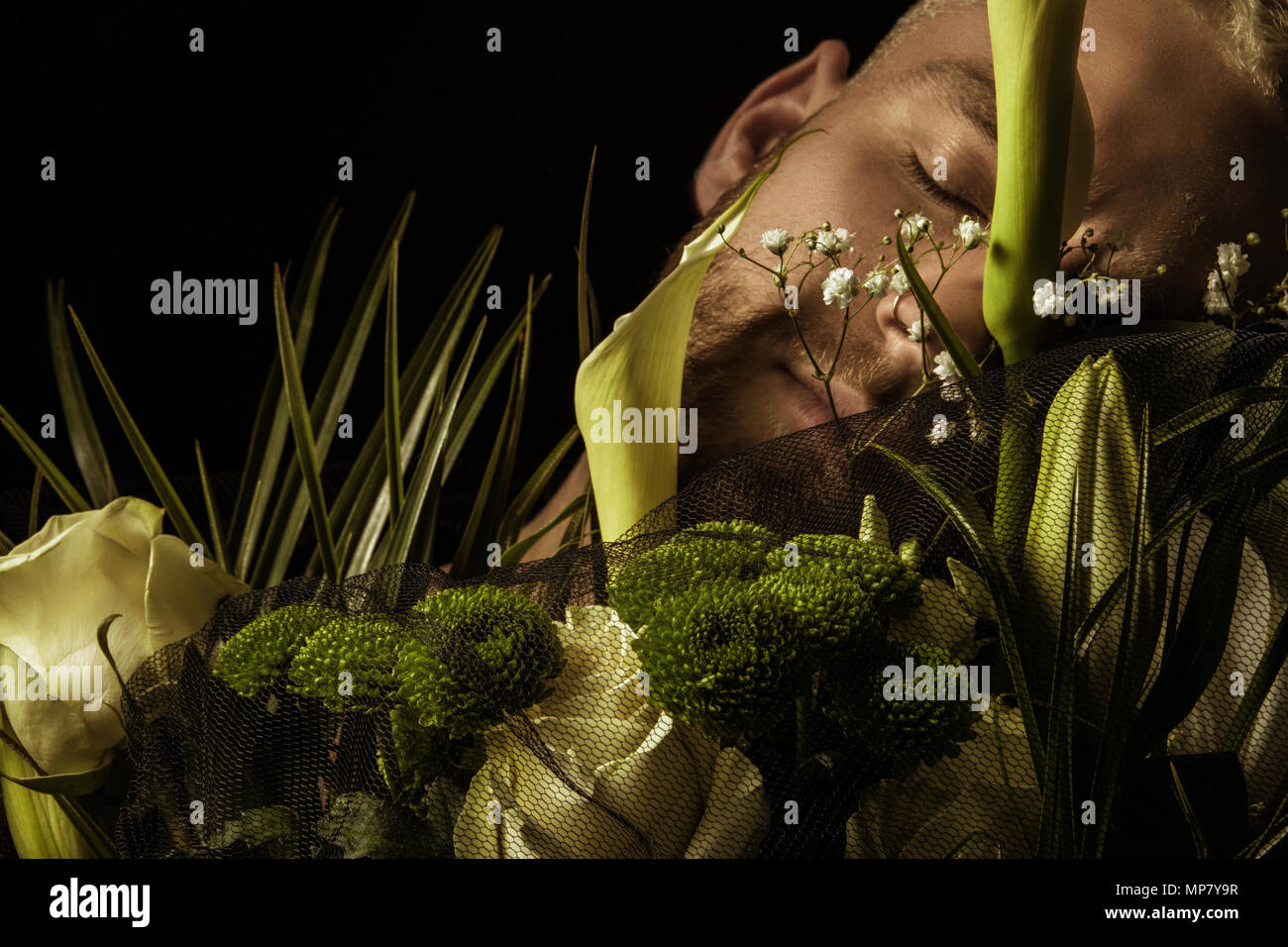 Elegante uomo bianco con bouquet di fiori su sfondo nero Foto Stock