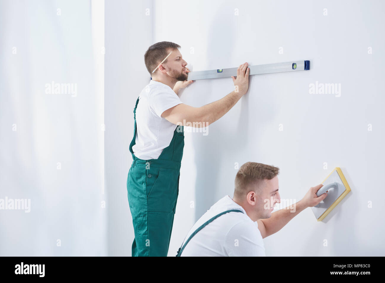 Due uomini professionisti che lavorano insieme a casa ristrutturazione Foto Stock