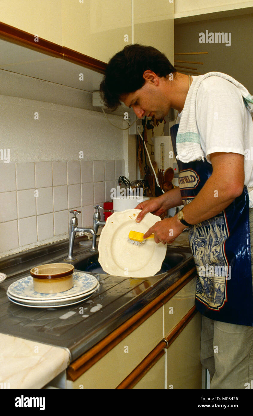 Pulizia, uomo lavaggio piatti lavello da cucina. Foto Stock