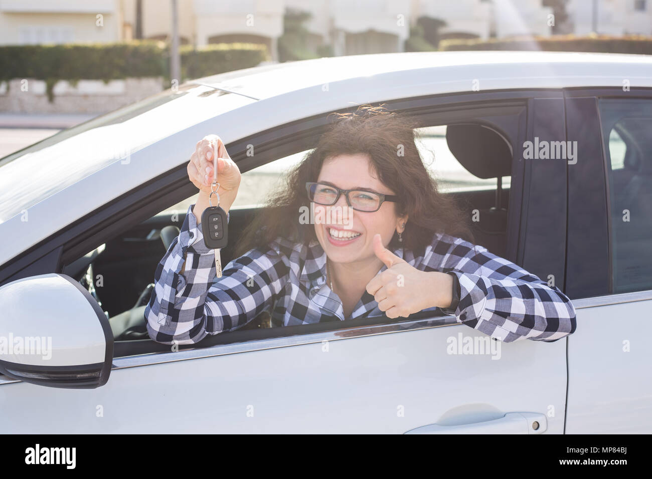 Giovane donna in auto mostra pollice in alto e il tasto Foto Stock
