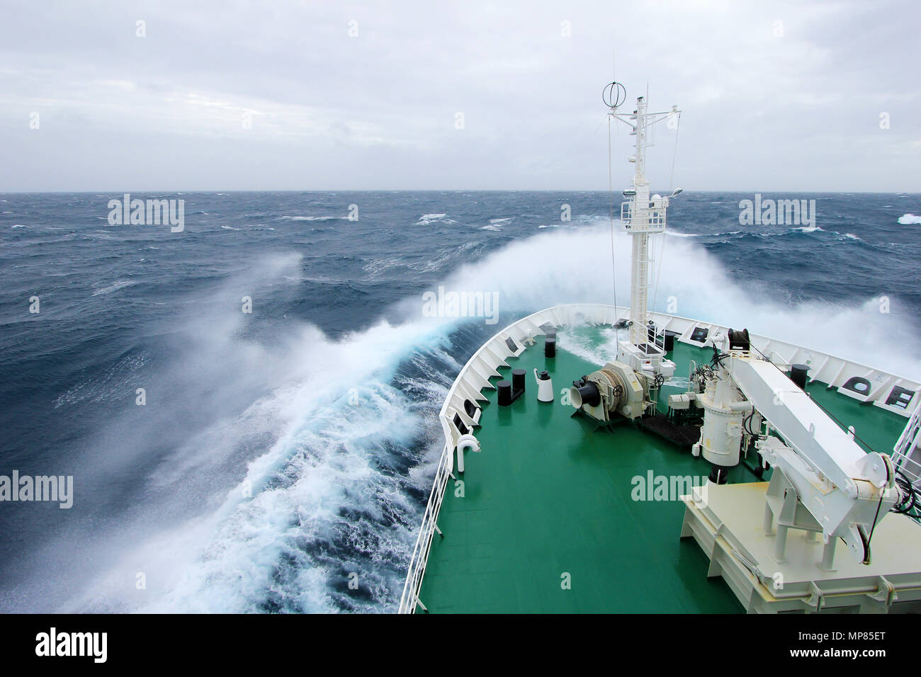 Prua di una grande nave da crociera è immergersi in un enorme onda spruzzi, maltempo sulla penisola Antartica, Antartide Foto Stock