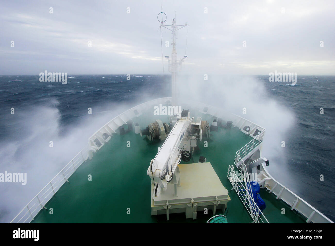 Prua di una grande nave da crociera è immergersi in un enorme onda spruzzi, maltempo sulla penisola Antartica, Antartide Foto Stock