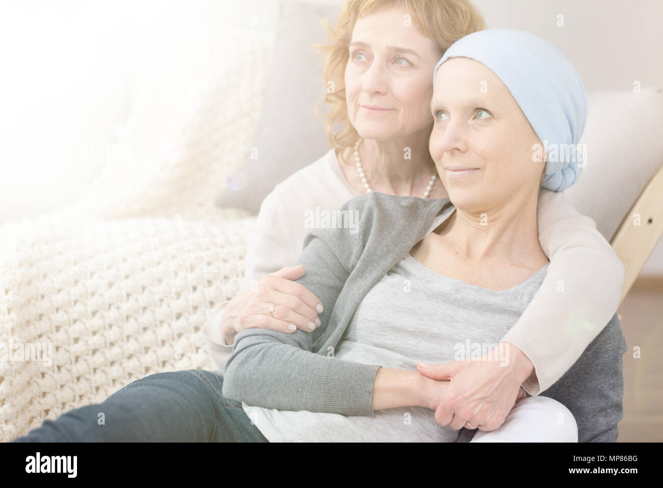 Donna felice con il cancro in un momento di relax a casa con gli amici Foto Stock