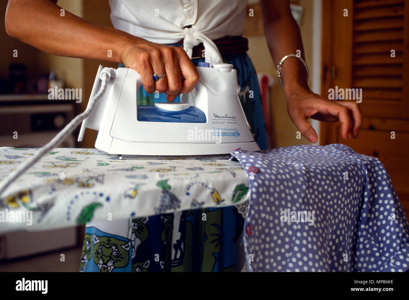Pulizia, domestici, lavanderia, Close up donna stiratura di capi di abbigliamento. Foto Stock