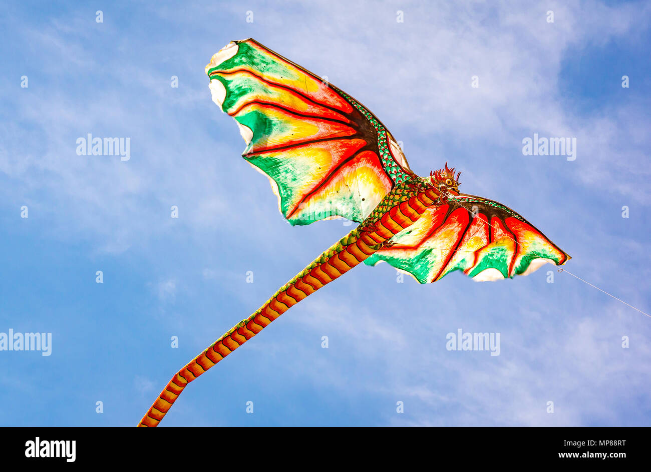Il kite indonesiano con una brutta testa di drago e una lunga coda battenti nel vento, Sanur, Bali, Indonesia, 21 aprile 2018 Foto Stock