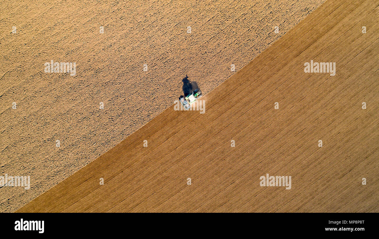 Foto aerea di un trattore arare un campo nella campagna francese Foto Stock