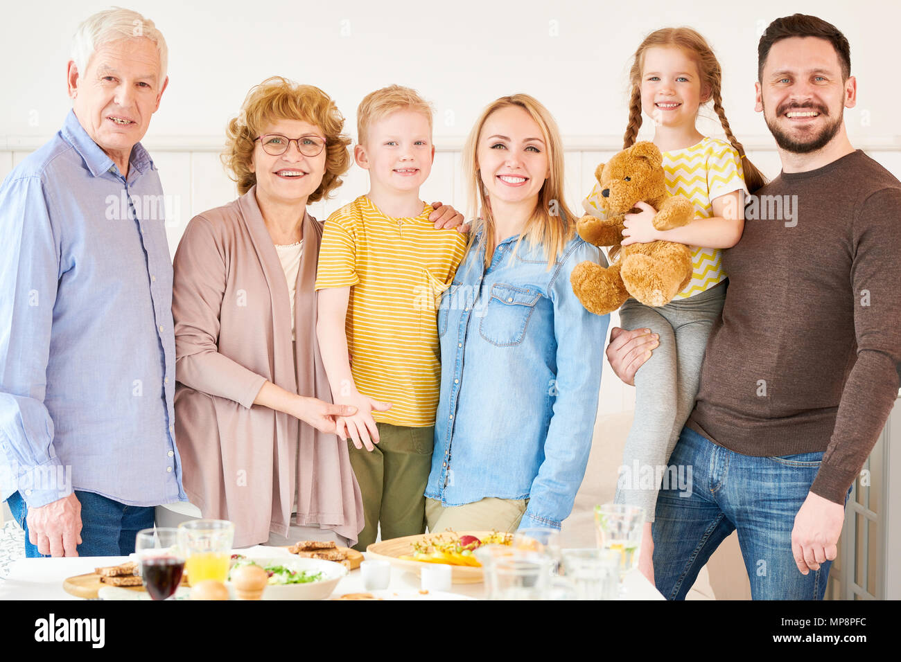 Due generazioni la famiglia in posa a casa Foto Stock