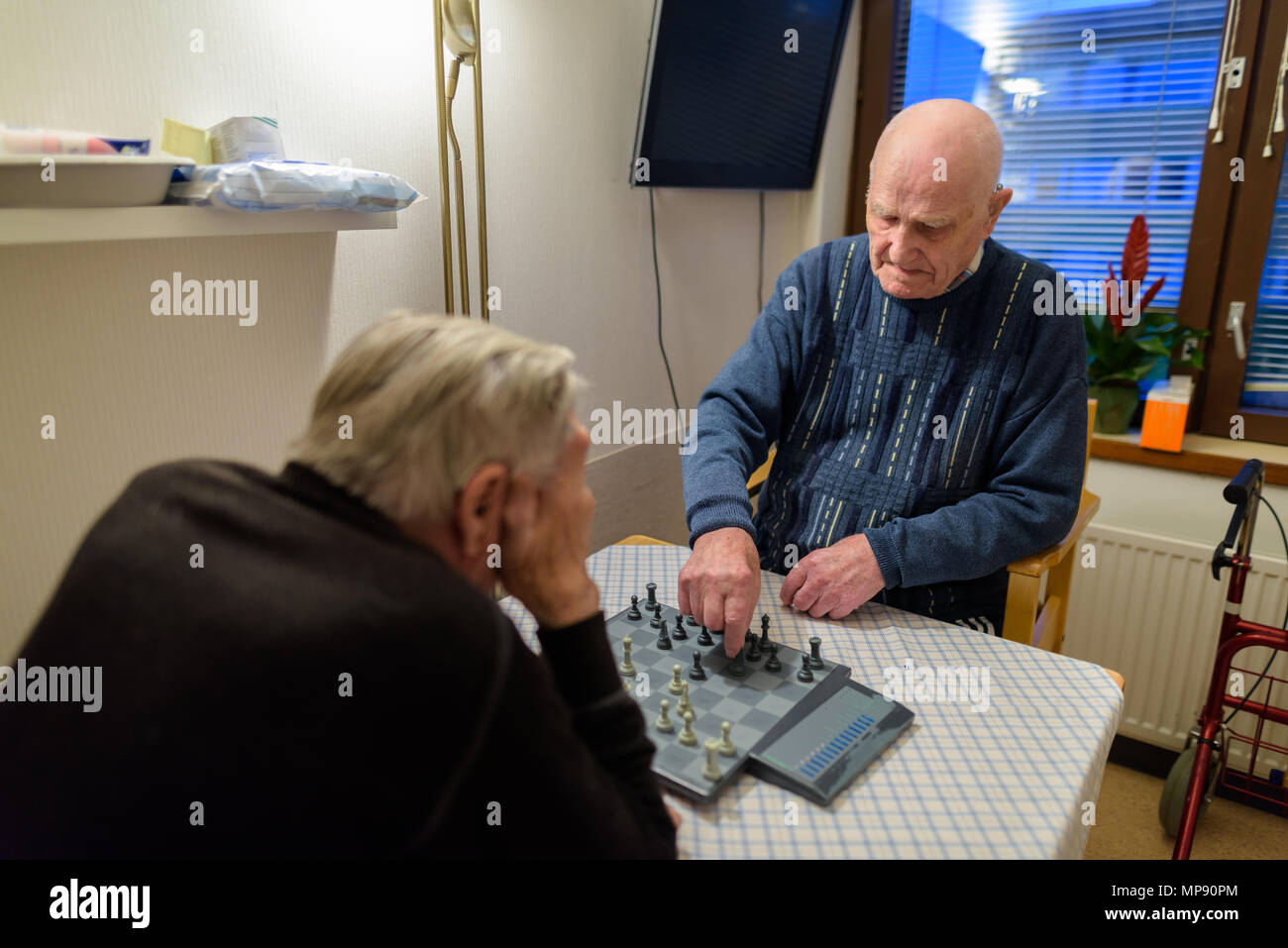 Due alti uomini giocare a scacchi mentre vi rilassate presso la casa di cura in T Foto Stock