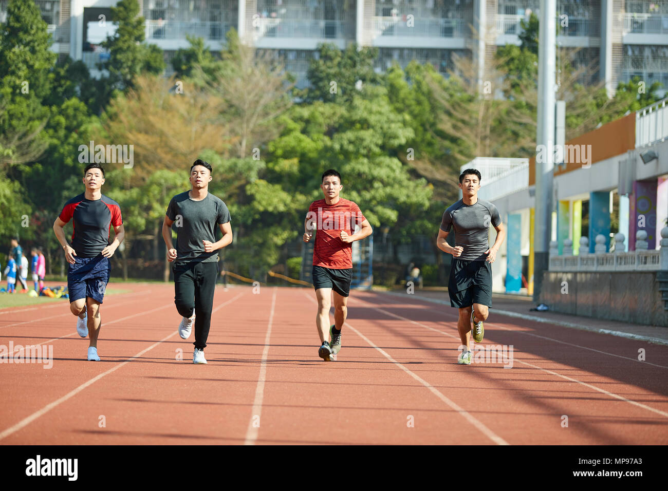 Giovani asiatici atleti adulti formazione in esecuzione sulla via, vista frontale. Foto Stock