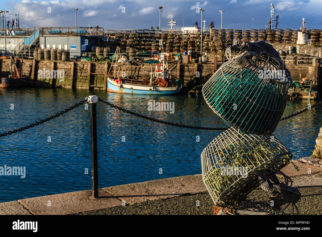 Lobster Pot scultura accanto a Brixham Harbour, con la barca da pesca e real lobster pot in background. Brixham, Devon. Marzo 2018. Foto Stock