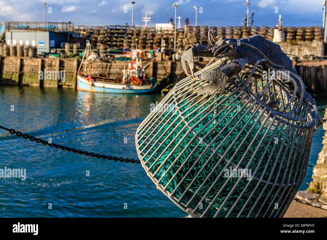 Lobster Pot scultura accanto a Brixham Harbour, con la barca da pesca e real lobster pot in background. Brixham, Devon. Marzo 2018. Foto Stock