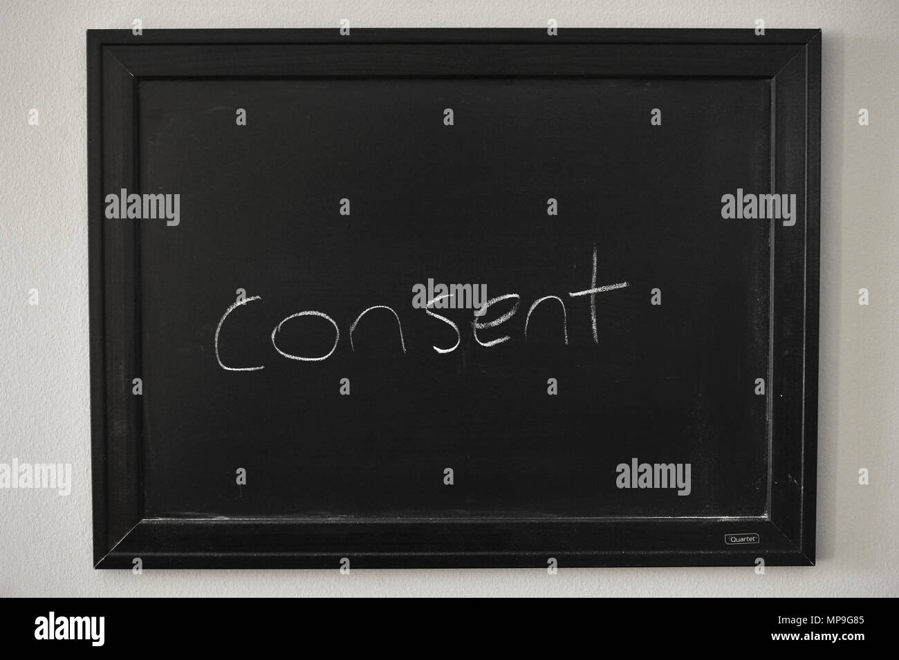 Consenso scritto in bianco gesso su una parete montata Blackboard. Foto Stock