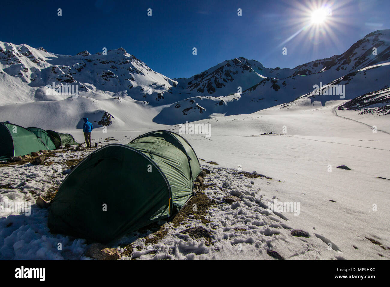 Le tende nel Caucaso innevate montagne al tramonto con il cielo blu Foto Stock