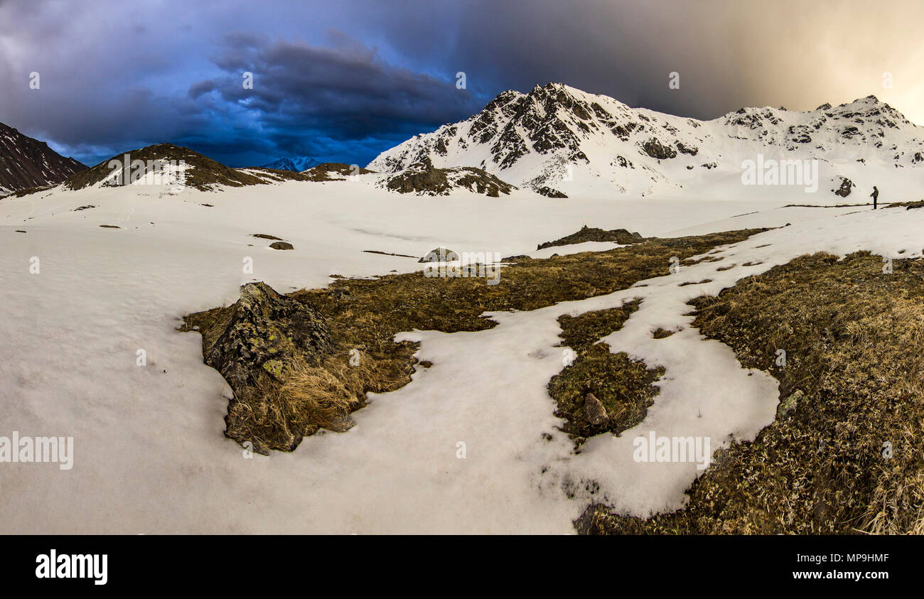Innevate montagne del Caucaso al tramonto con storm su sky Foto Stock
