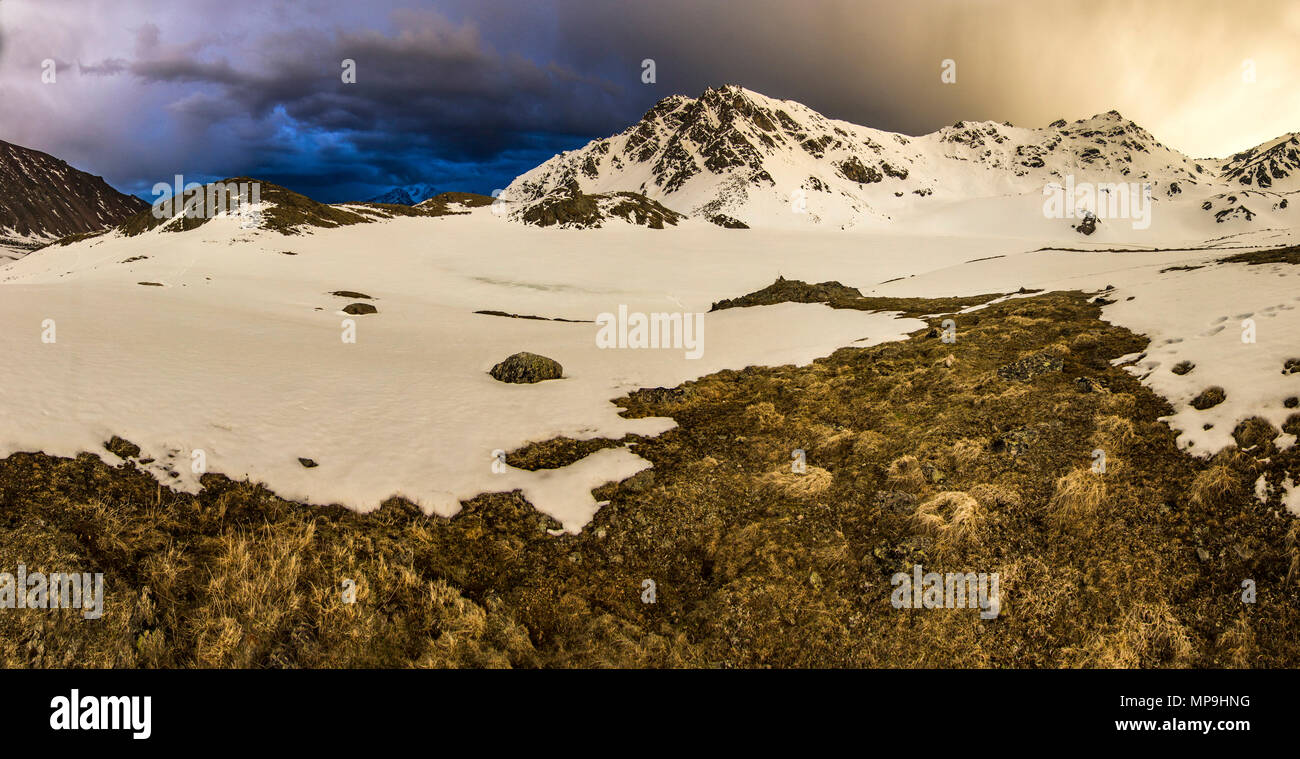 Innevate montagne del Caucaso al tramonto con storm su sky Foto Stock