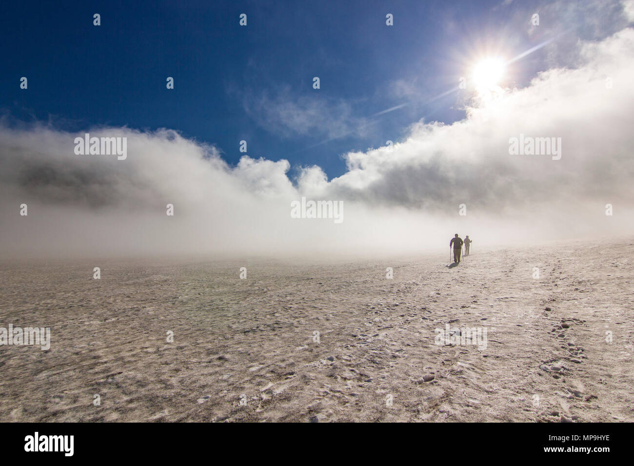 Due uomini su un campo nevoso in kamchatka montagne con le nuvole e il cielo sopra Foto Stock