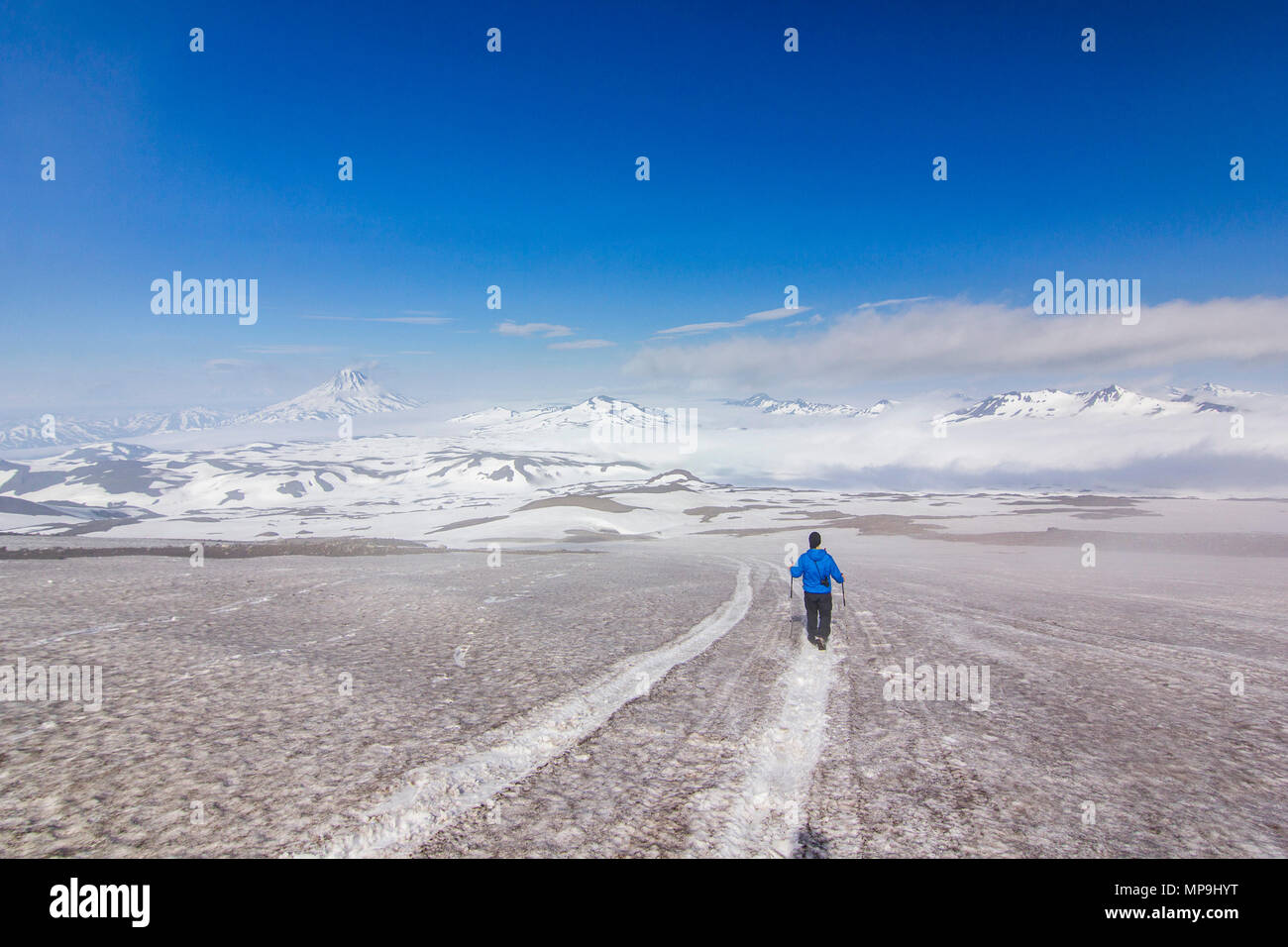 L'uomo sul campo nevoso in kamchatka le montagne vicino al coperto di neve vulcani Foto Stock