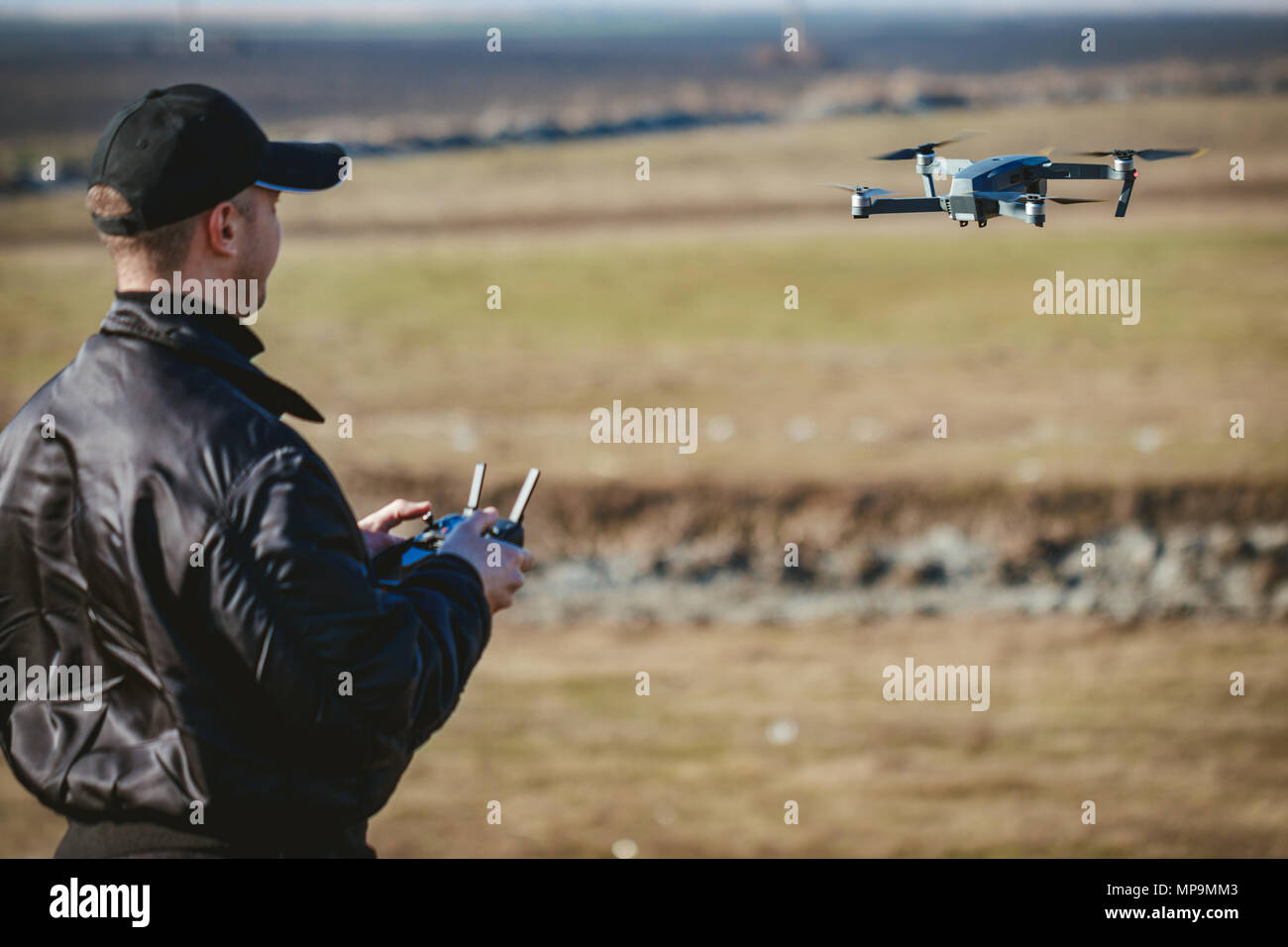 Giovane Azienda controller remoto nelle sue mani e a prendere foto aerea con piccole e compatte del drone. Messa a fuoco selettiva. Foto Stock