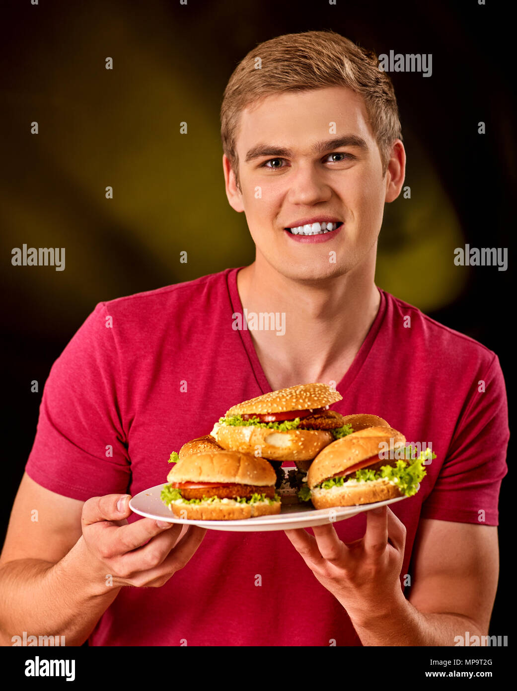 L'uomo mangiare patatine e hamburger sul tavolo. Foto Stock