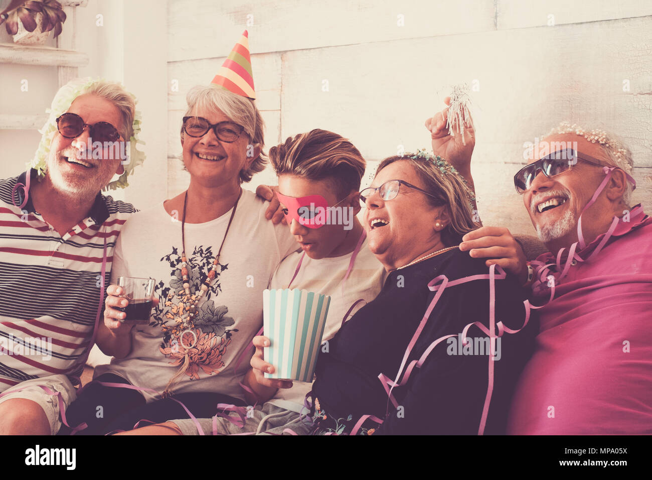 Festa a casa per i nonni e nipote. età senior e adolescente divertirsi ith sorrisi e ridere. vintage filtro per look rétro Foto Stock