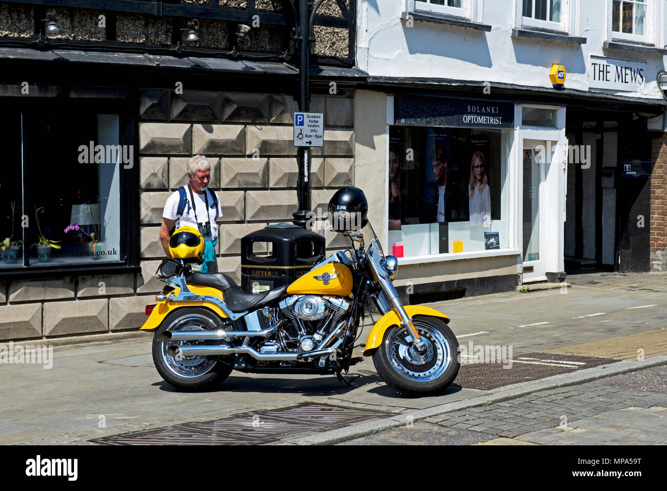 L'uomo ammirando Harley Davidson Moto, St Ives, Cambridgeshire, England Regno Unito Foto Stock