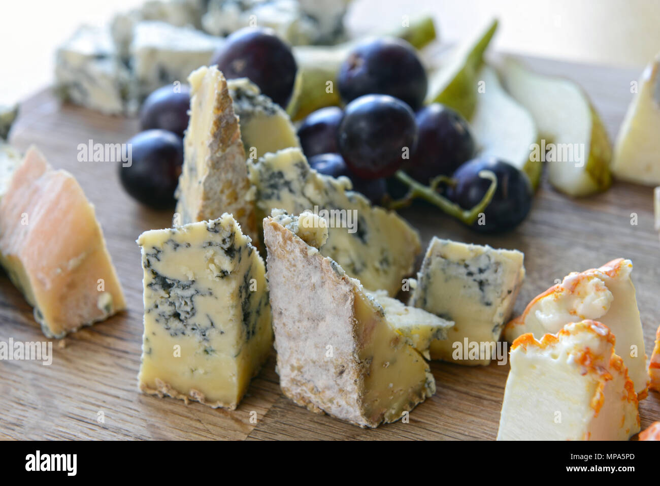 Set di formaggio con stampo su una tavola di legno con uva e pere Foto Stock