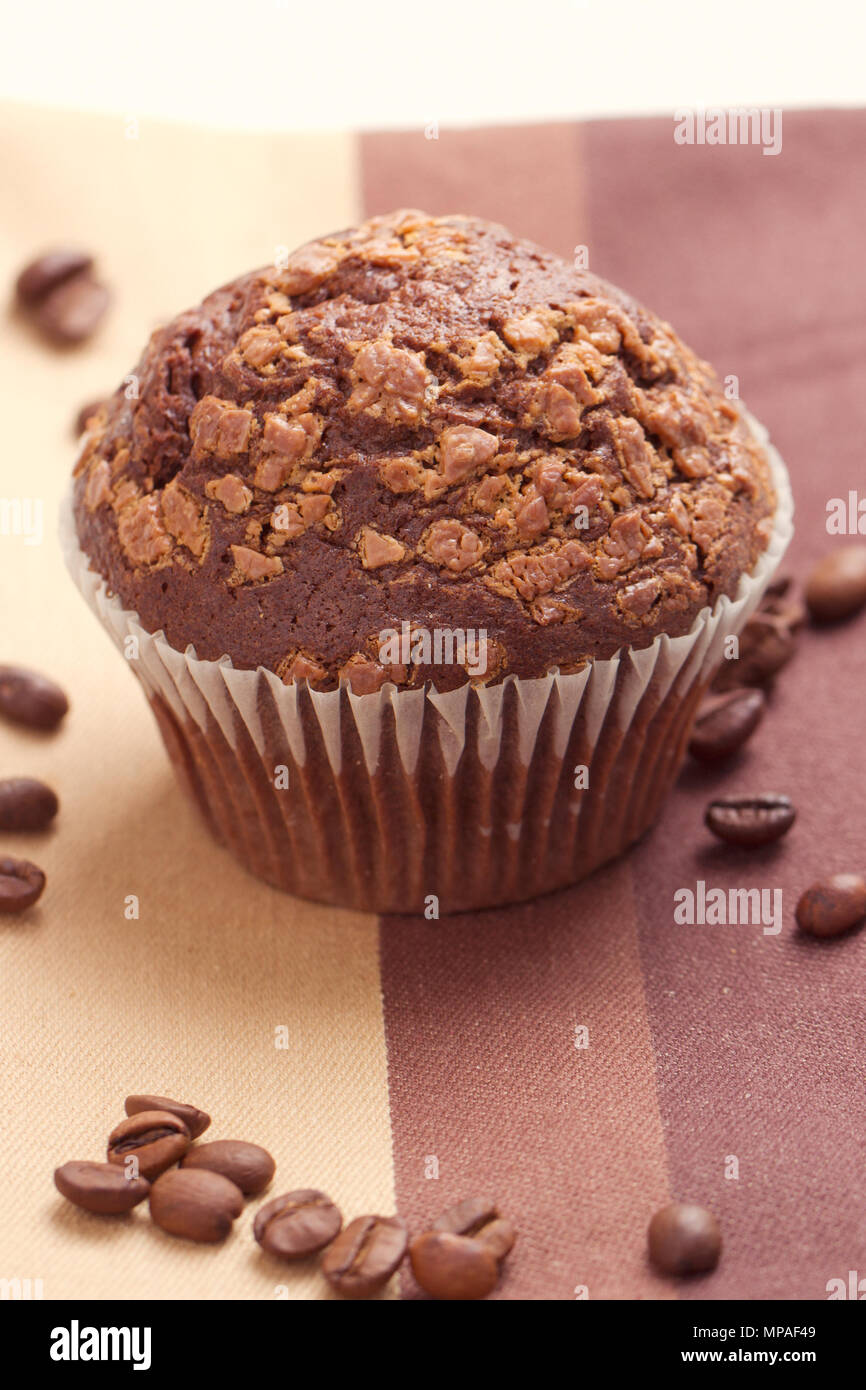 Muffin al cioccolato e chicchi di caffè sul tavolo Foto Stock