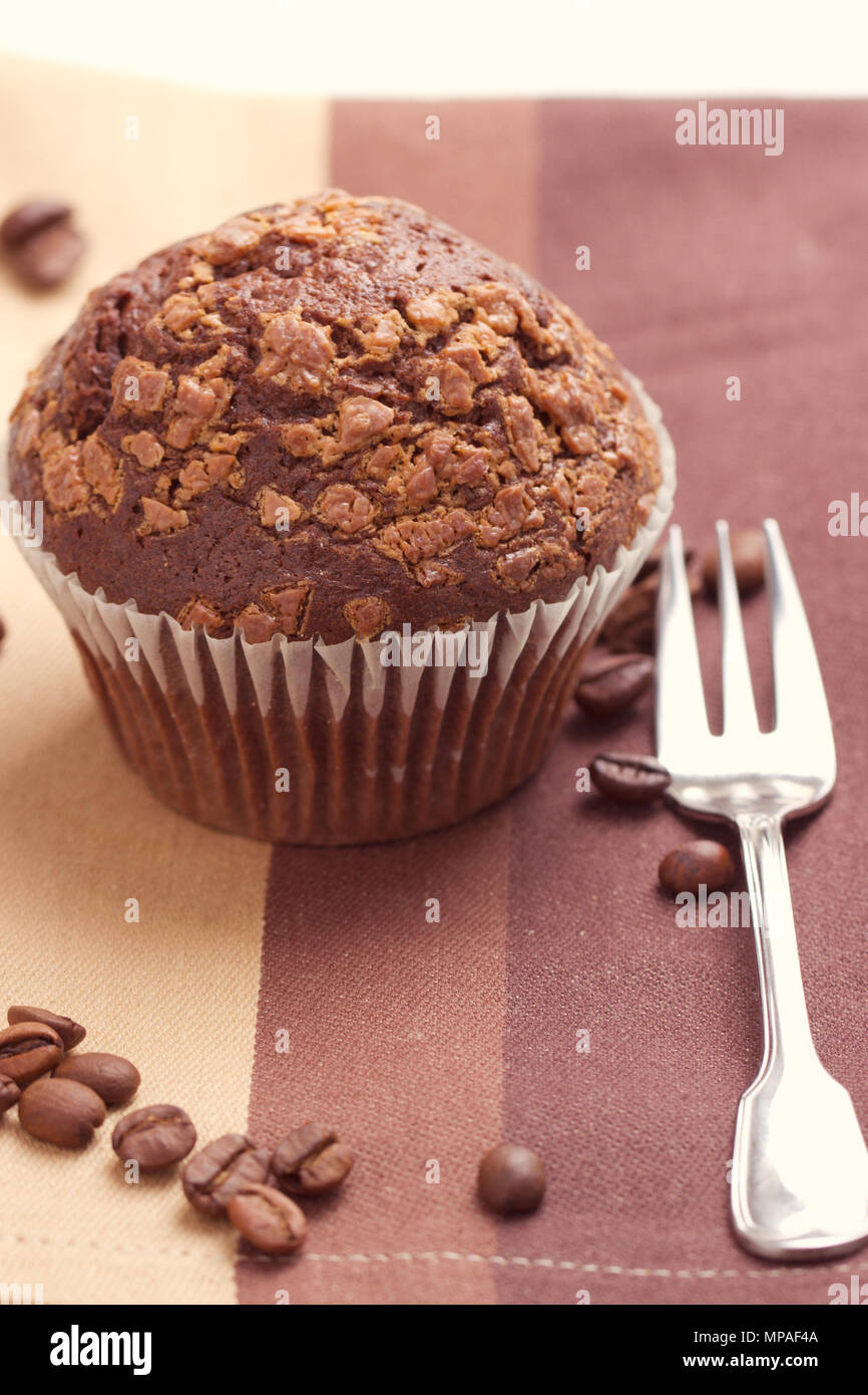 Muffin al cioccolato e chicchi di caffè sul tavolo Foto Stock