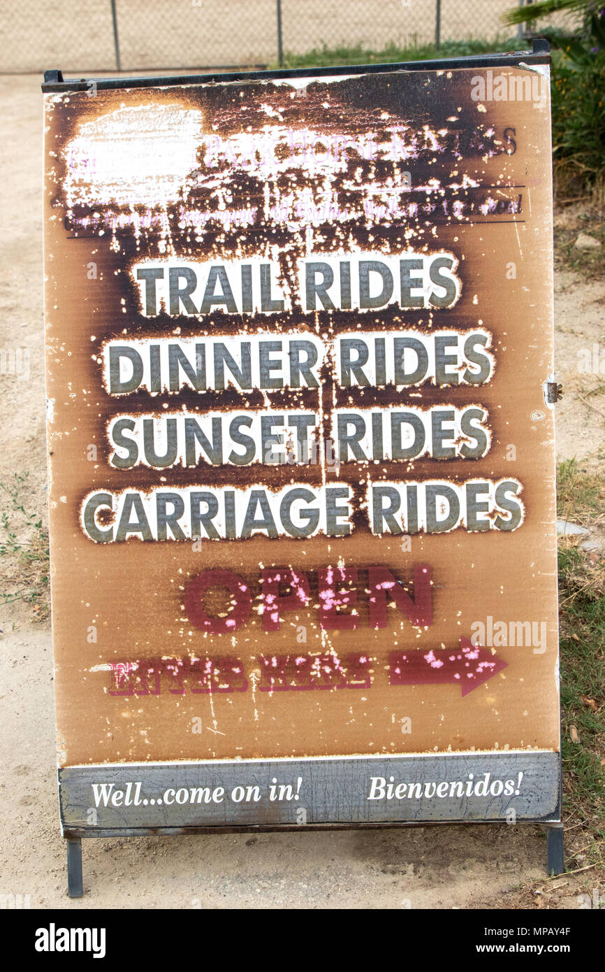 Una fotografia di un'annata weathered noleggio cavallo segno pubblicità Trail Rides, cena giostre, Tramonto passeggiate e gite in carrozza Foto Stock