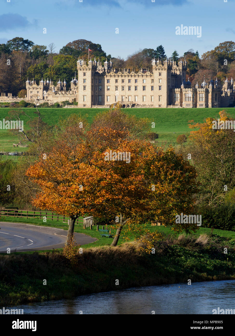 Il castello di pavimenti, a Kelso, sede del duca di Roxburghe, countryu casa aperta al pubblico. Con l'autunno alberi, visto oltre il Tweed River. Foto Stock