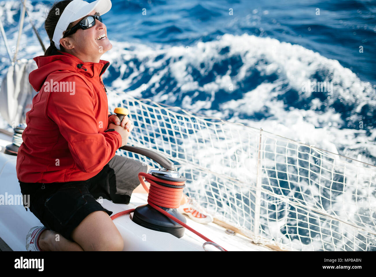 Attraente donna forte in barca a vela con la sua barca Foto Stock