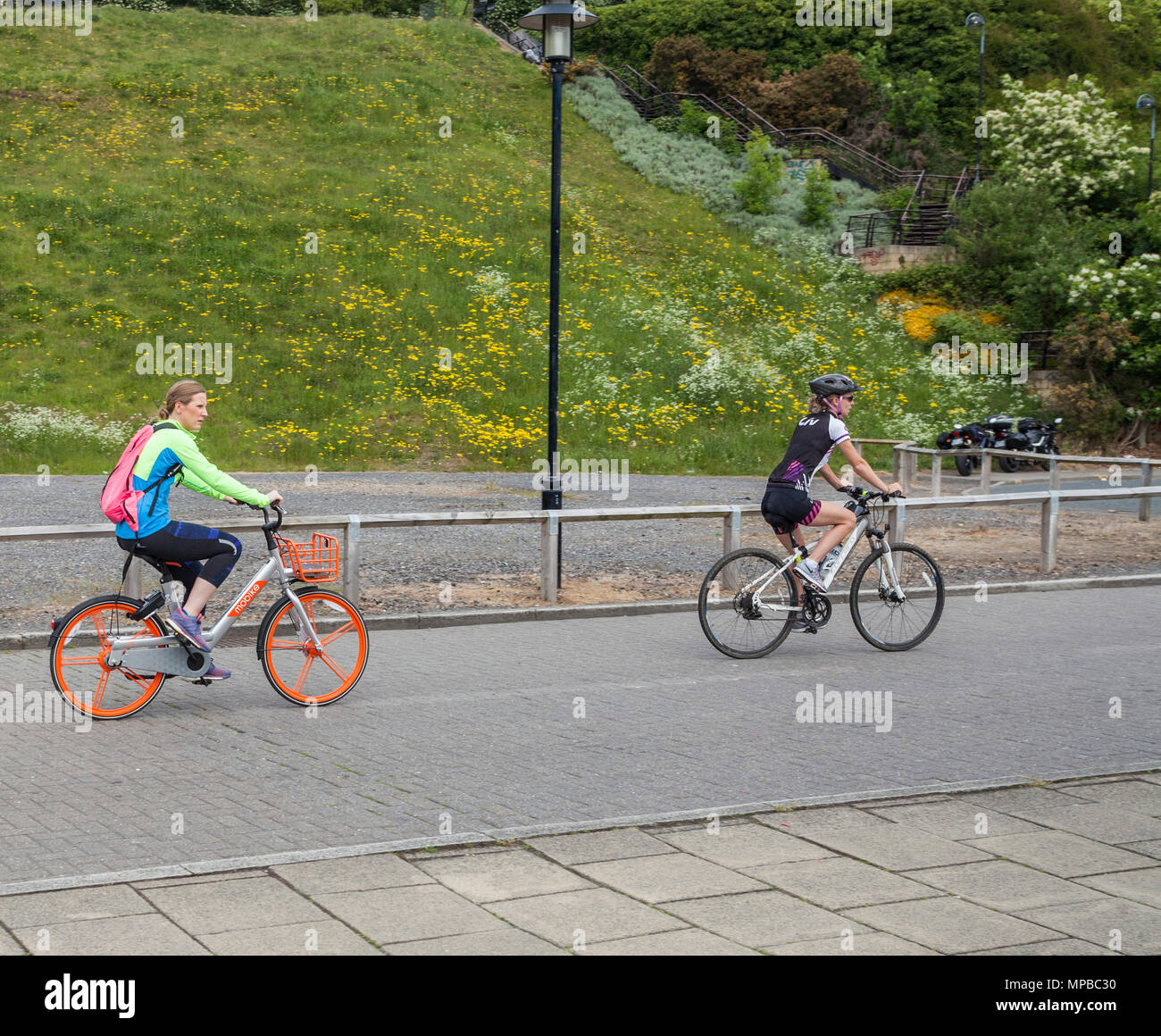 Due ciclisti femmina a cavallo lungo la banchina, Newcastle upon Tyne,l'Inghilterra,UK Foto Stock
