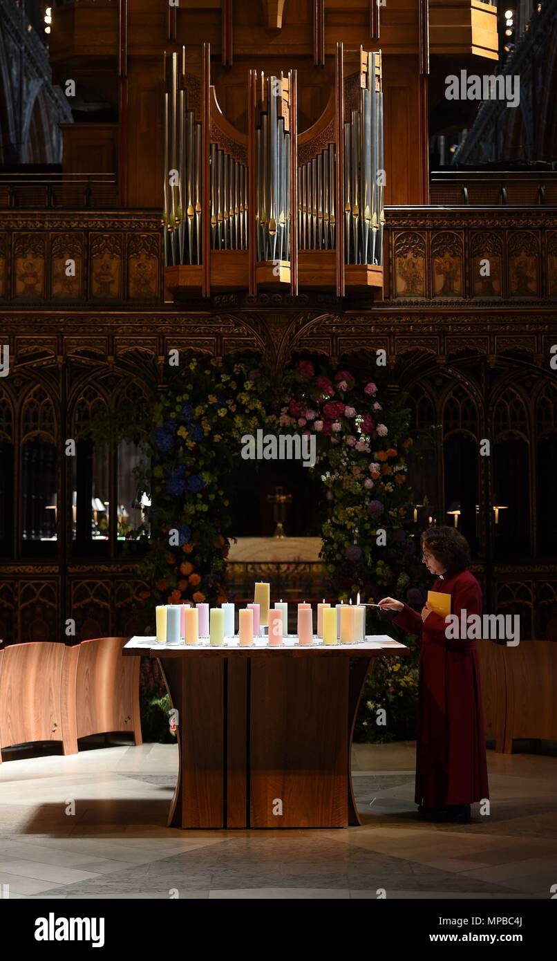 Un membro del clero luci candele per le vittime durante la Manchester Arena Servizio nazionale di commemorazione alla Cattedrale di Manchester per contrassegnare un anno poiché l'attacco su Manchester Arena. Foto Stock