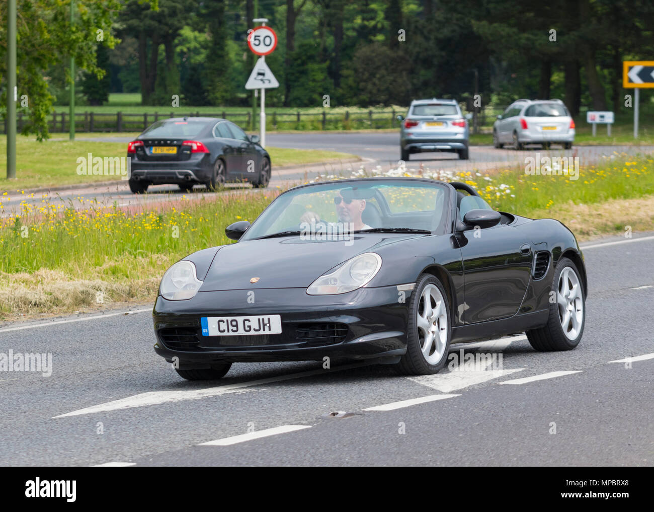 Nero Porsche Boxter cabrio auto sportiva con la parte superiore verso il basso in un giorno caldo nel Regno Unito. Porsche Boxter 2004 modello. Foto Stock