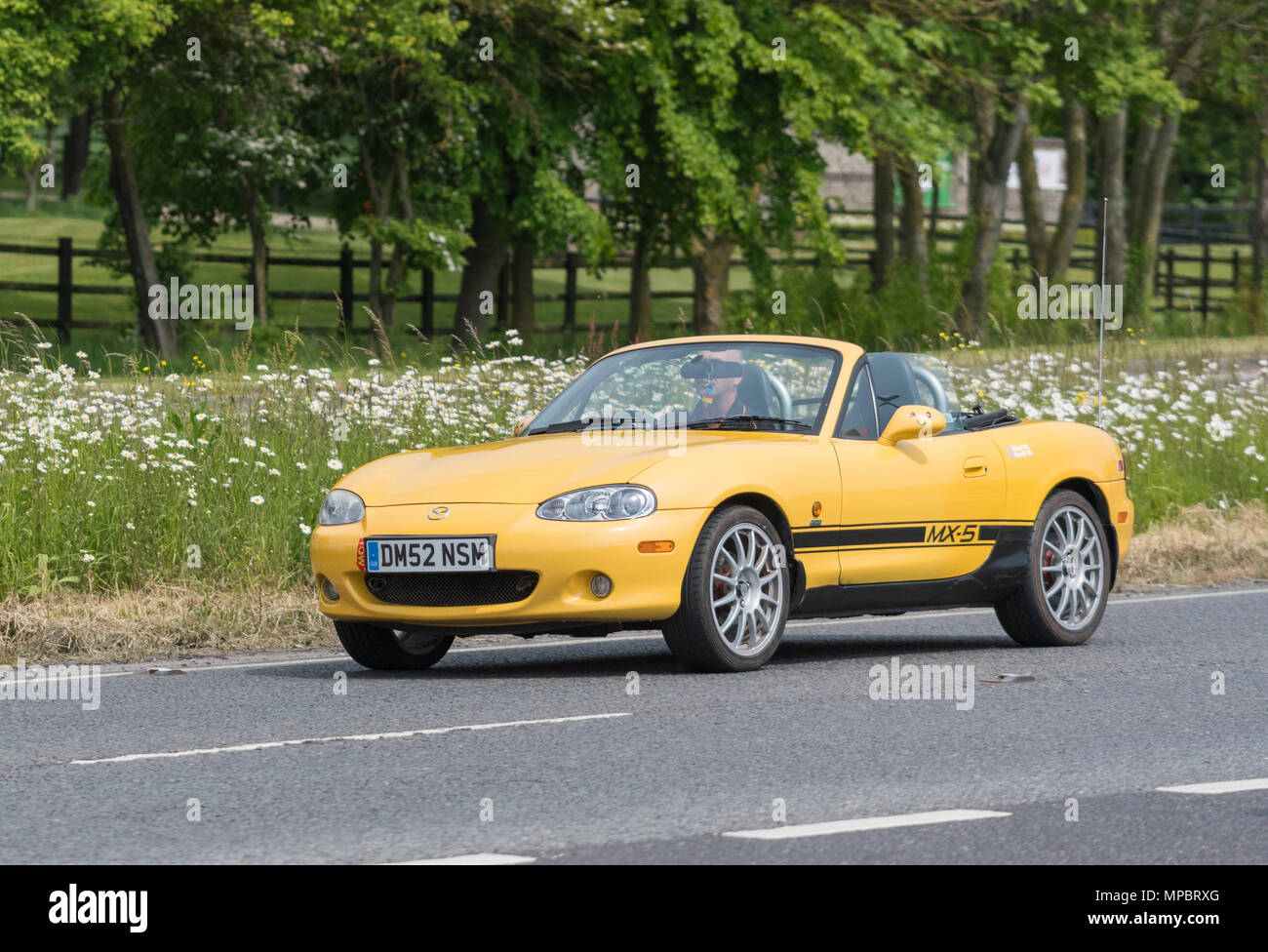 Giallo Mazda MX-5 Arizona convertibile auto sportive dal 2002, con la parte superiore verso il basso su una strada britannica in un giorno caldo nel Regno Unito. Mazda soft top auto. Foto Stock