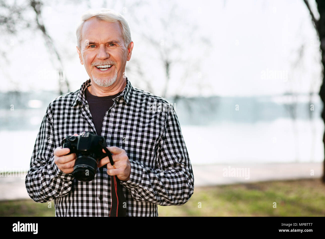 Gioioso uomo senior tenendo la fotocamera Foto Stock